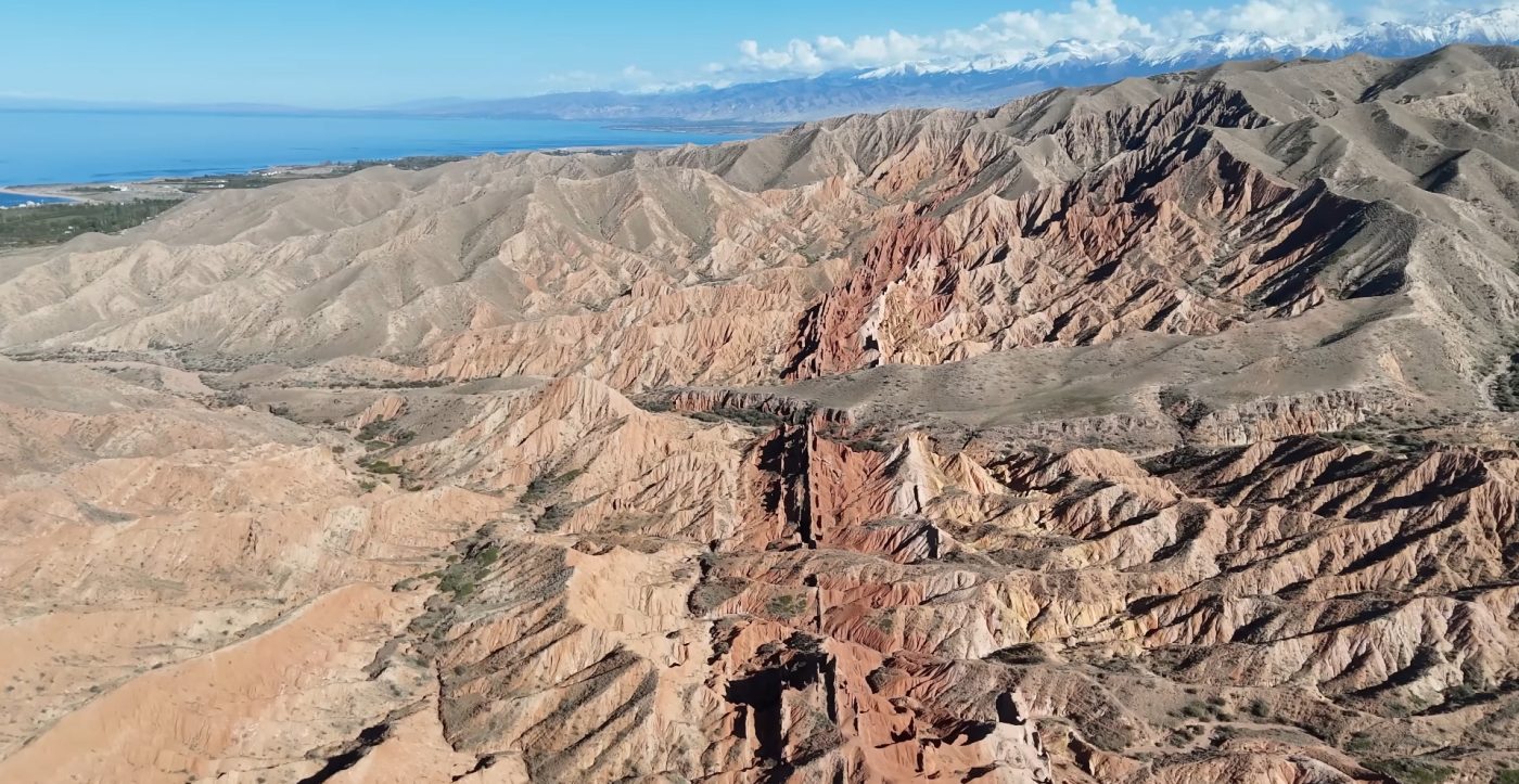 Rocky lakeshore of Issyk Kul with crystal water and mountain horizon